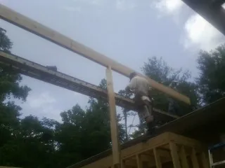 Carpenter setting a ridge beam over a new addition frame — Ice Dam Removal by Roofing Brothers in Susan
