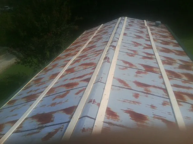 Rusted metal roof panels with new wood purlins before replacement — Storm Damage Roof Repair in Susan by Roofing Brothers