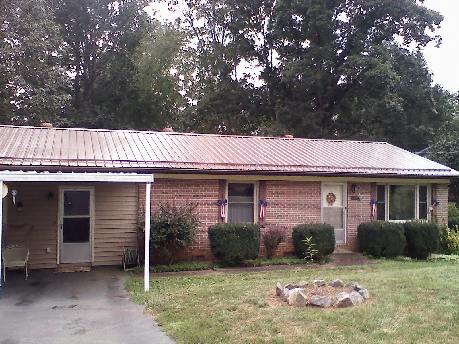 Bronze metal roof and carport on a brick ranch home — Roof Repair work by our crew in Susan